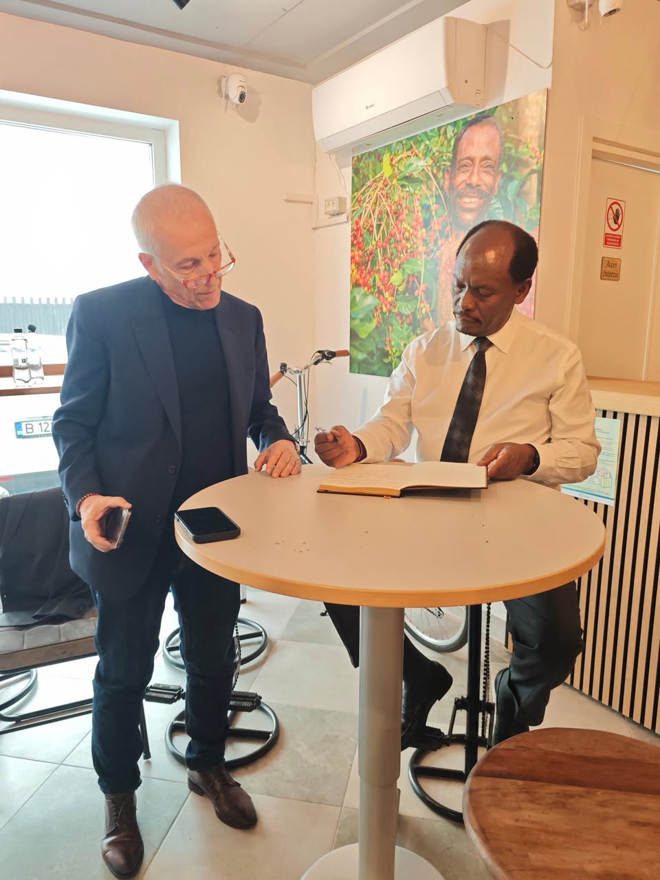 H.E. Hon. William Kabogo Gitau signs the guestbook at the Kenyan Cultural Centre, with Florin Pîrkea, Chairman of the Bilateral Chamber of Commerce